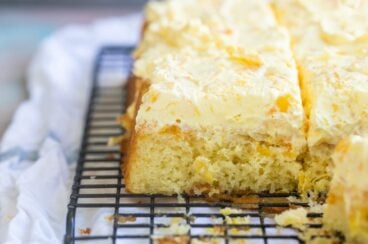 Squares of Pig Pickin' Cake on a black cooling rack.