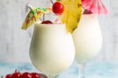 Two Piña Coladas on a counter.