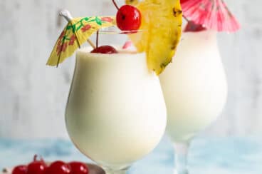 Two Piña Coladas on a counter.