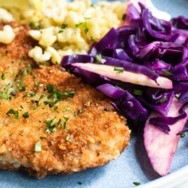 A plate of pork schnitzel, spatzle, and braised red cabbage.