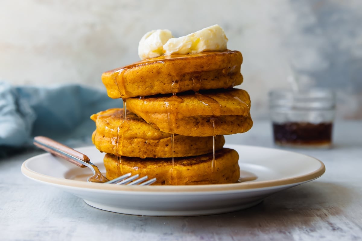 A stack of pumpkin pancakes on a white plate.