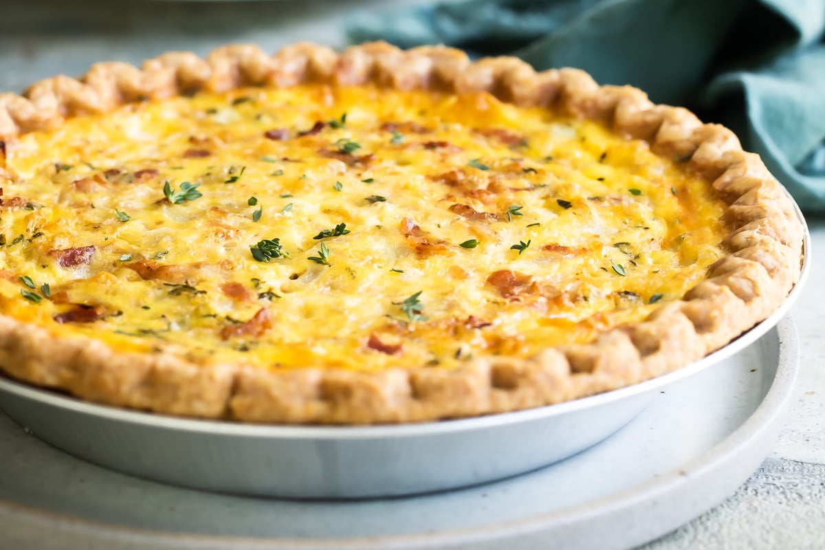 A quiche Lorraine in a silver pie pan.