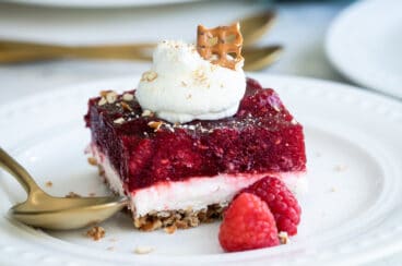 A slice of raspberry pretzel jello salad on a white plate.
