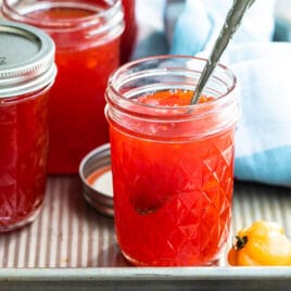 Jars of red pepper jelly on a tray.