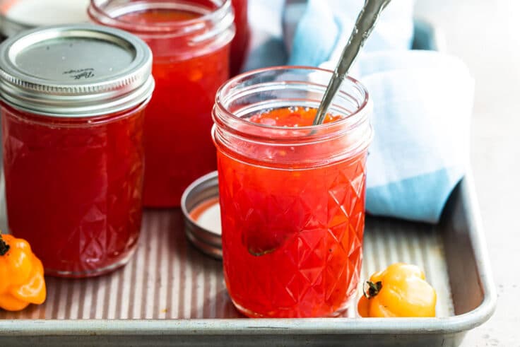 Jars of red pepper jelly on a tray.