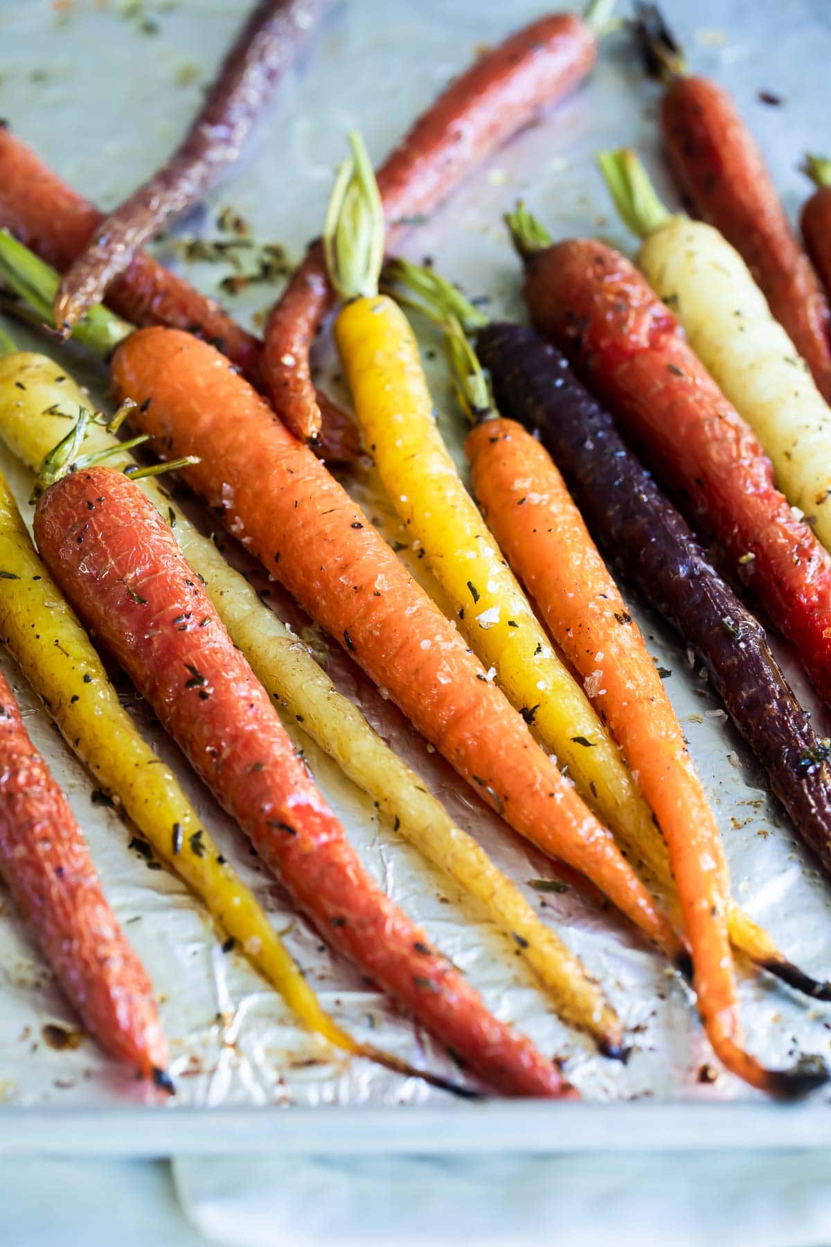 Roasted carrots on a parchment paper lined baking sheet.