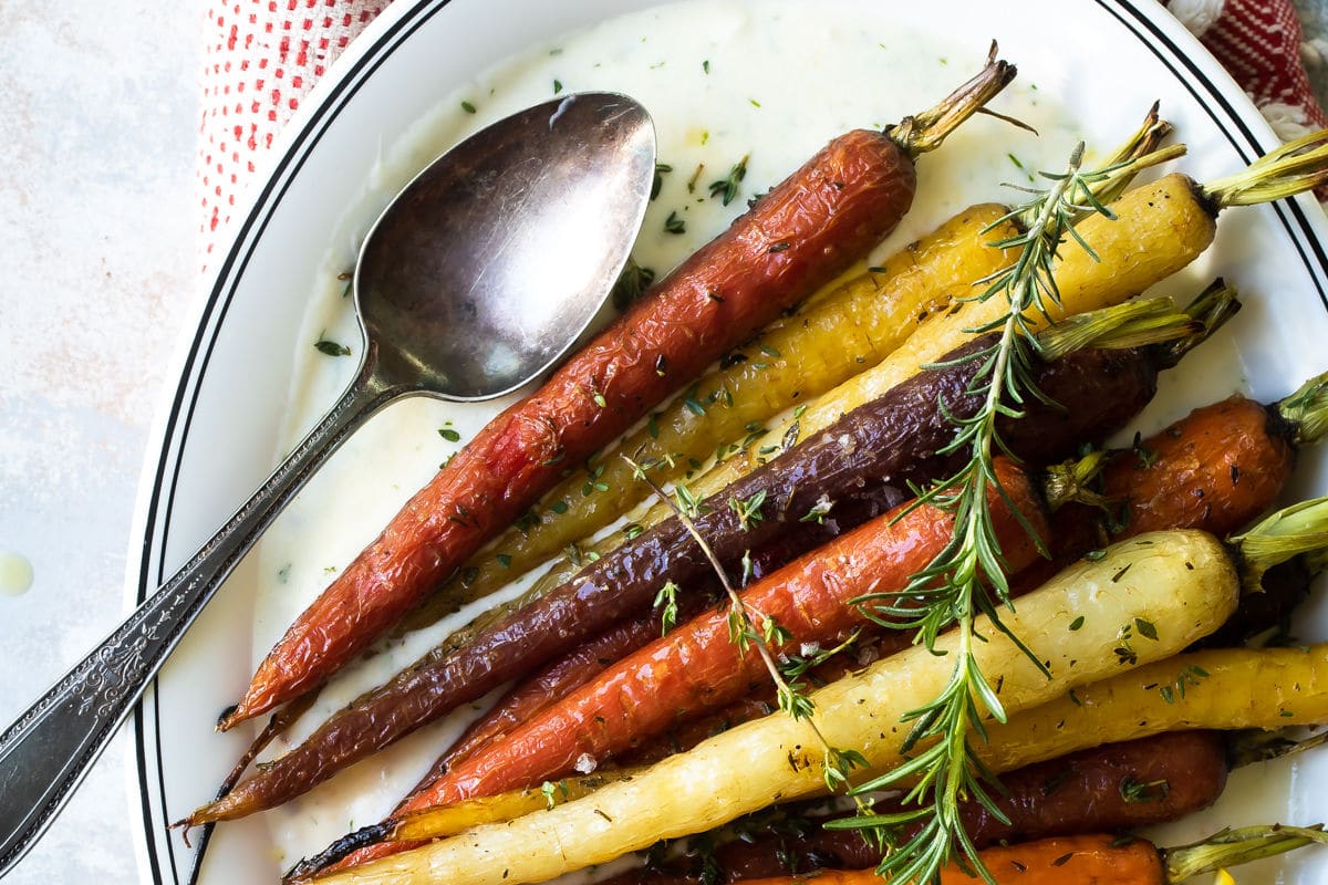 Roasted carrots on a white oval platter.