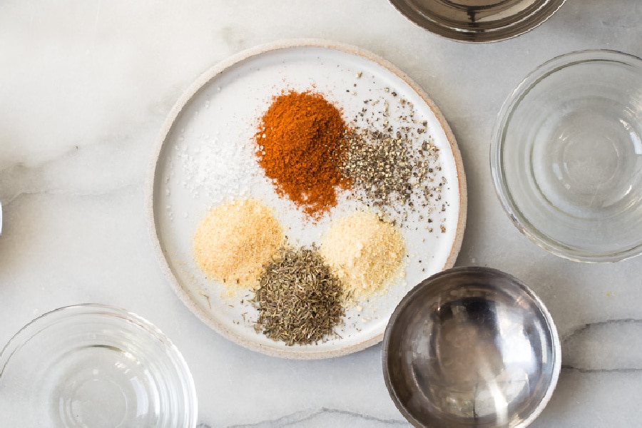 Rotisserie chicken seasoning ingredients on a white plate.