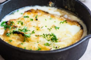 Saganaki in a black cast iron skillet.