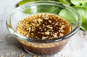 Sesame dressing in a clear bowl on a countertop.