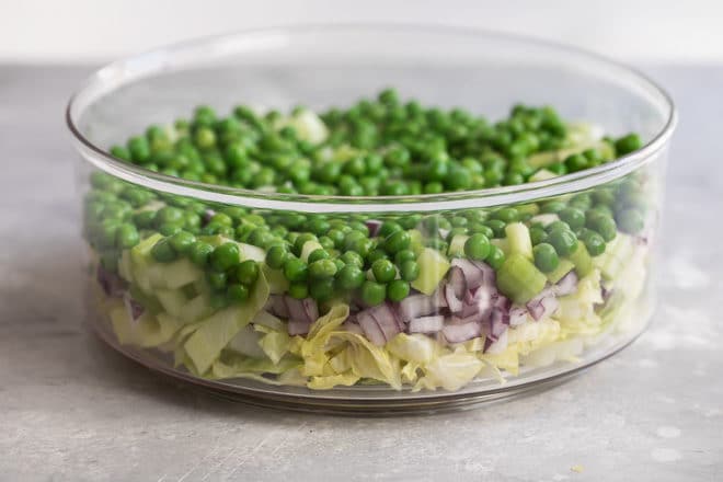 Seven layer salad in a clear dish.