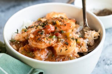 Shrimp Étouffée in a white bowl over rice.