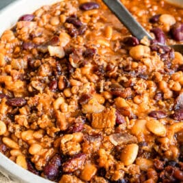 Slow cooker calico beans in a white serving dish.