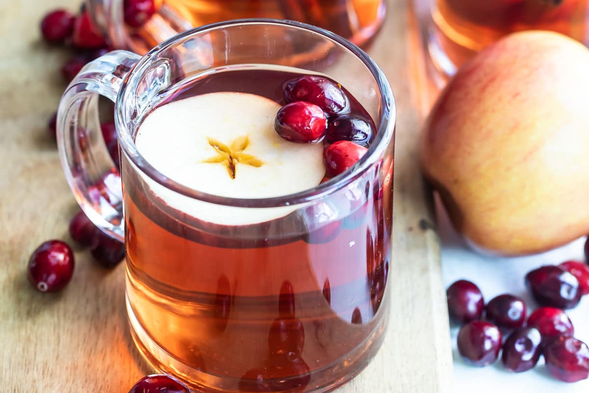 Slow cooker cranberry apple cider in a clear mug.