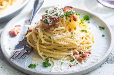 Spaghetti carbonara on white plates.