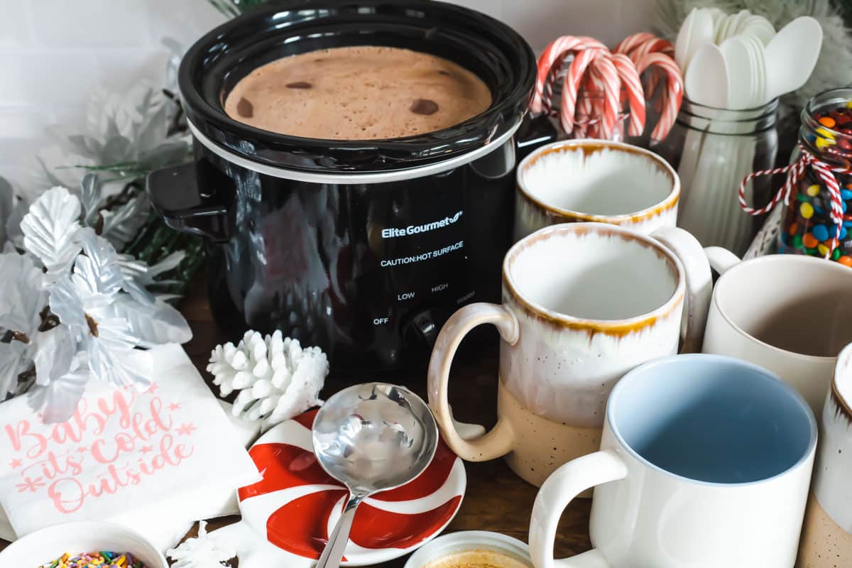 A crockpot full of hot chocolate on a hot cocoa bar.