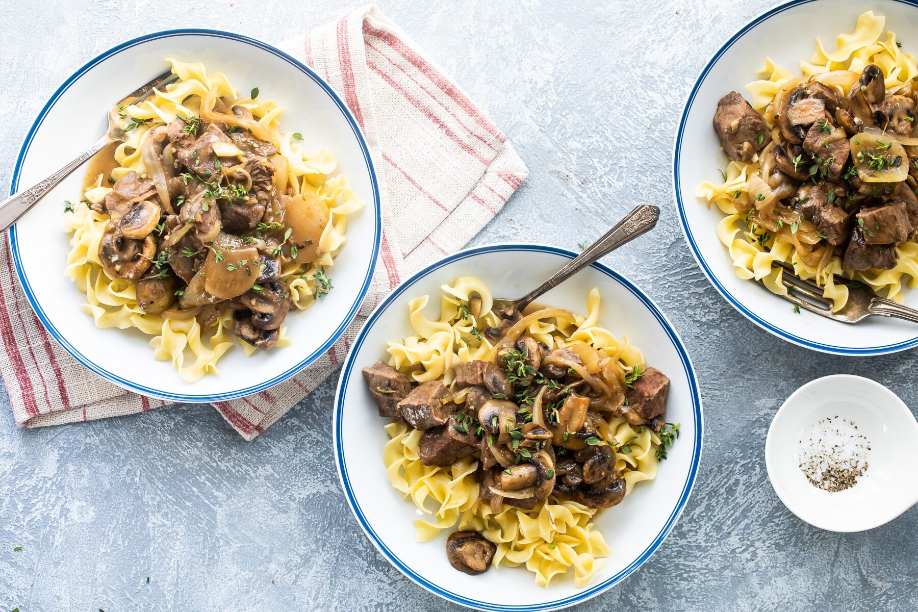 Steak tips with mushroom gravy in white bowls.