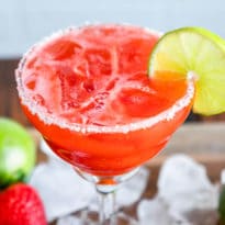 Strawberry margarita in a clear stemmed glass.