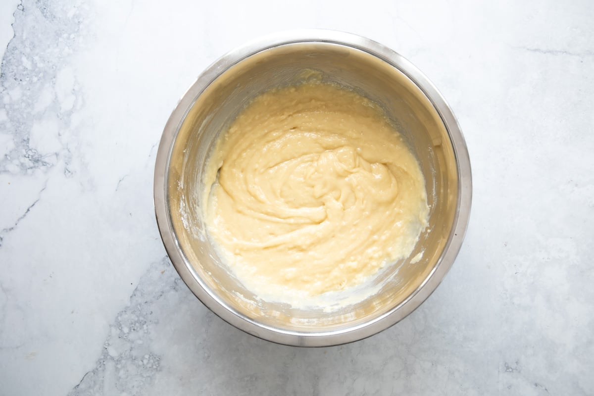 Batter for strawberry rhubarb muffins in a metal mixing bowl.