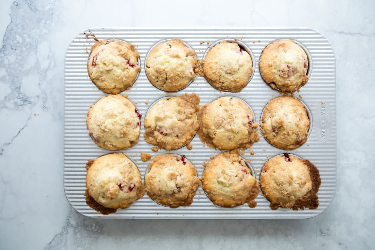 Strawberry rhubarb muffins in a muffin pan.