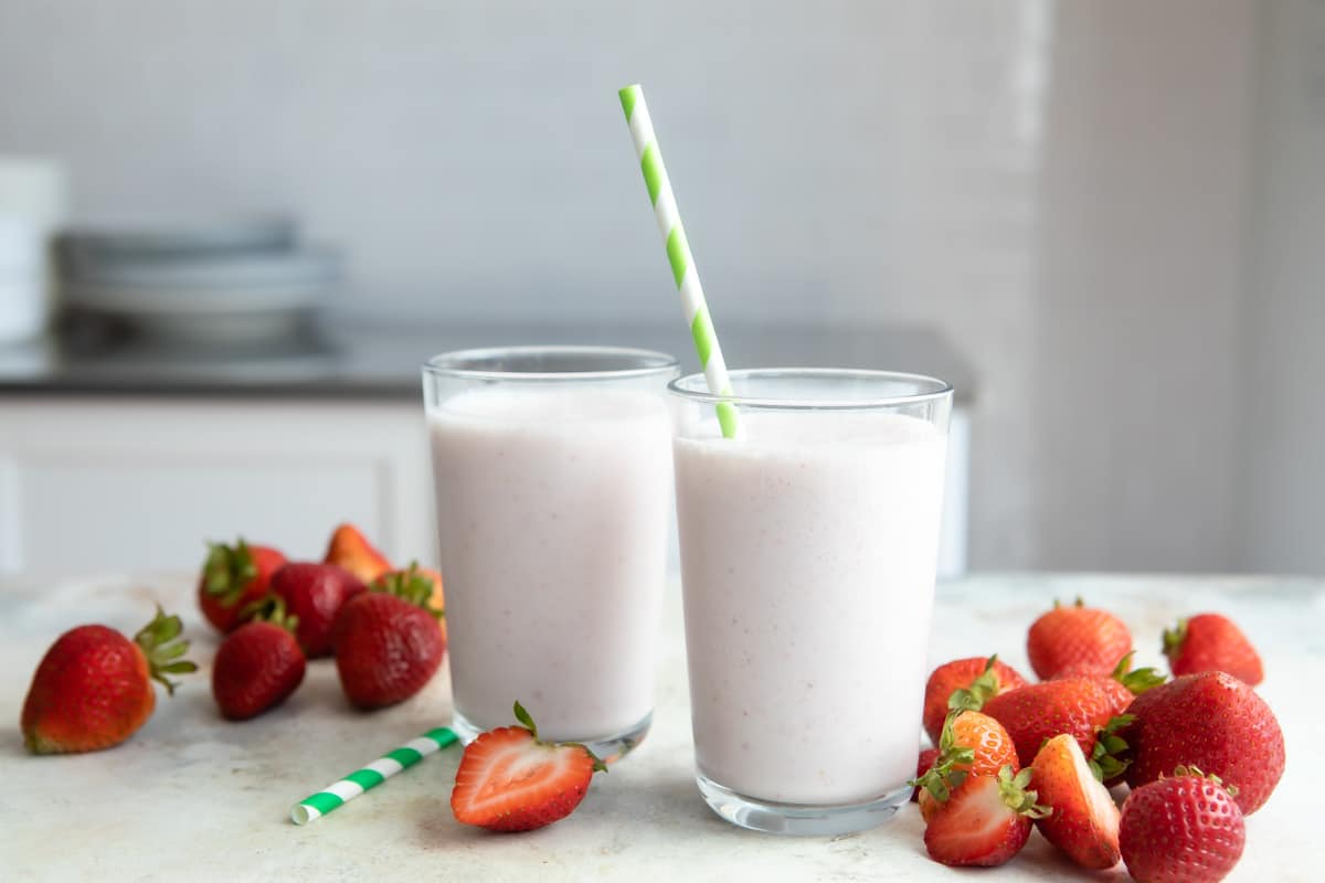 2 glasses full of strawberry smoothie.