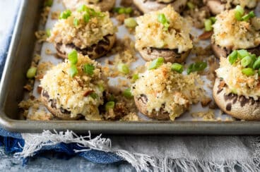 A baking sheet full of stuffed mushrooms.