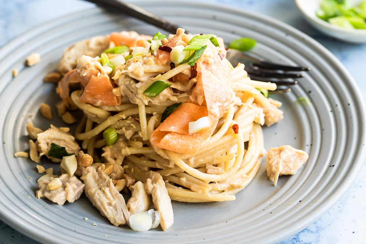 Thai peanut chicken noodles on a gray plate.