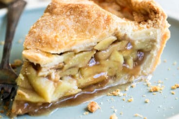 A slice of apple pie on a light blue plate.