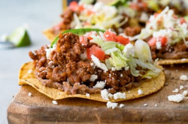 A tostada on a wooden cutting board.