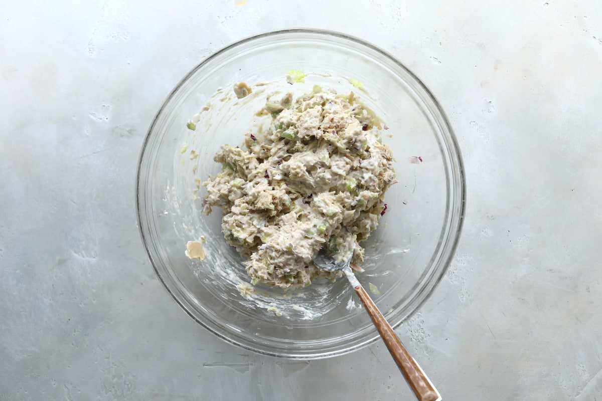 Tuna salad in a clear mixing bowl.
