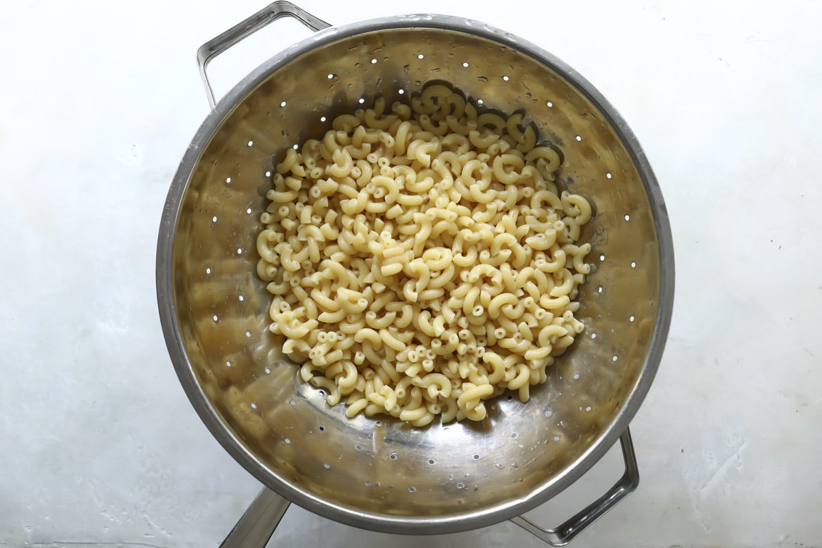 Cooked elbow macaroni in a colander.