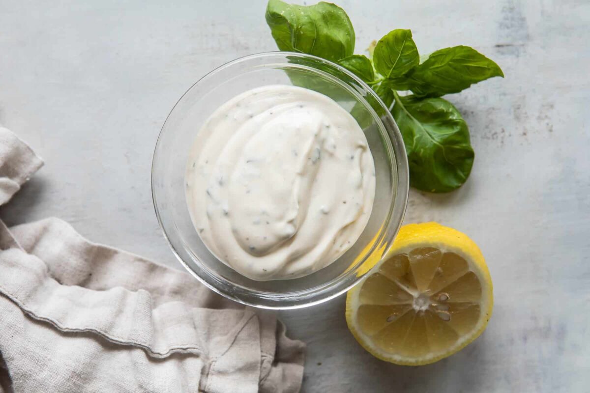 Basil mayonnaise in a clear dish.