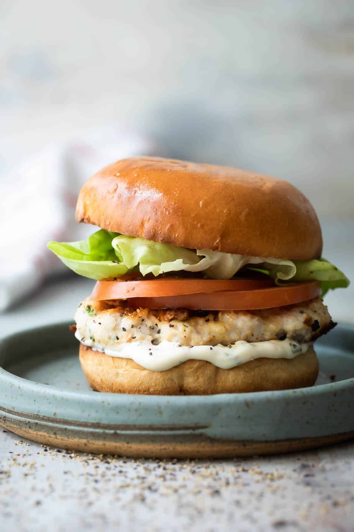 A turkey burger on a blue plate.