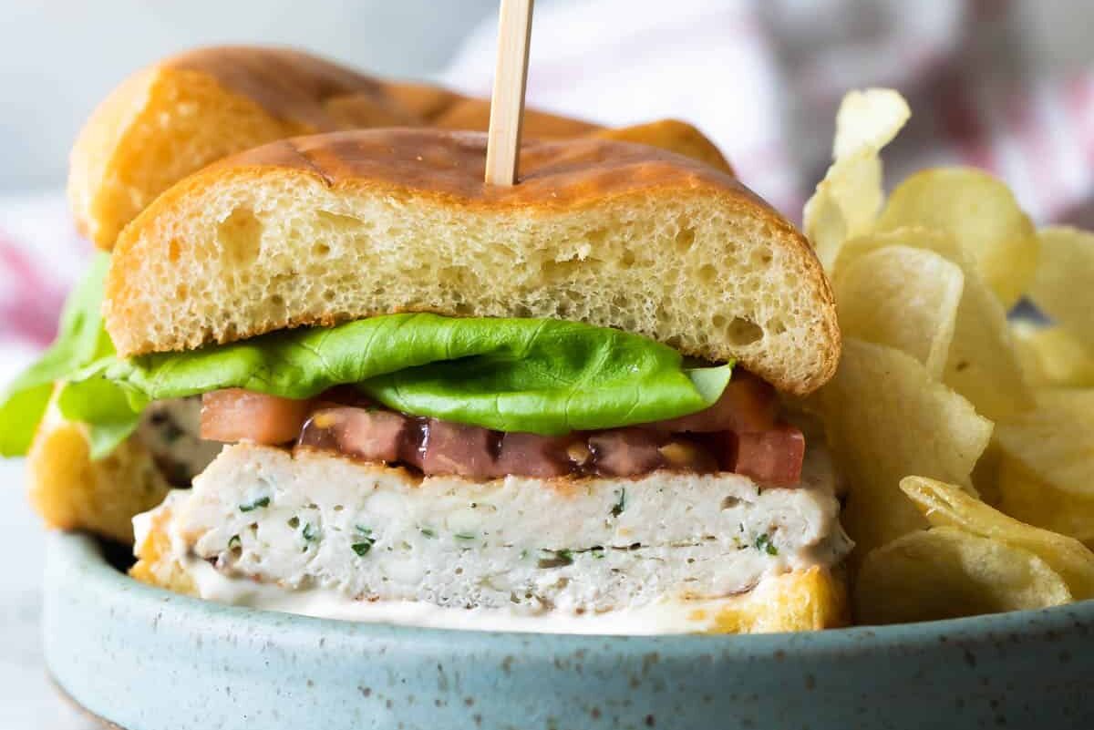 A turkey burger on a blue speckled plate.