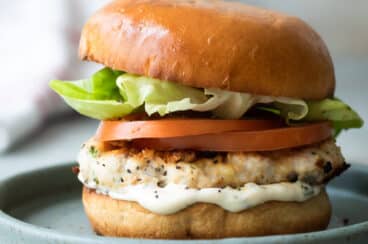 A turkey burger on a blue plate.