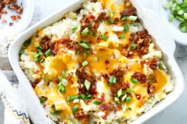 Twice baked potato casserole in a square, white casserole dish.