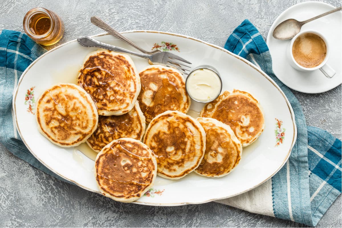 A platter of vegan pancakes with maple syrup on top.