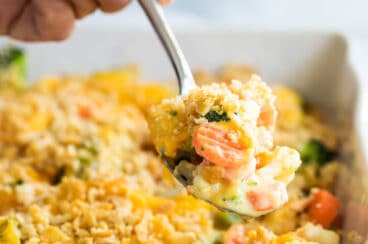 A pan of vegetable casserole with Velveeta and cracker crumbs.