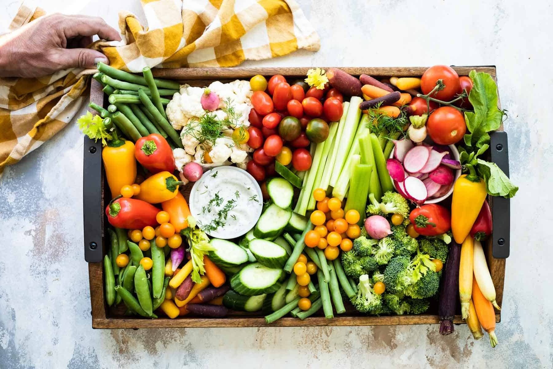 Someone setting down a veggie platter on a countertop.