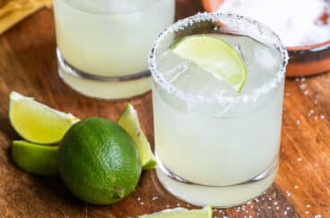 A wooden board with 2 Virgin margaritas on it.