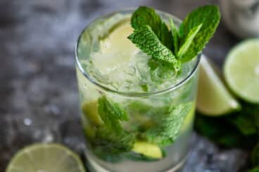 A virgin mojito mocktail in a clear glass.