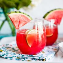Watermelon agua fresca in glasses with wedges of watermelon.