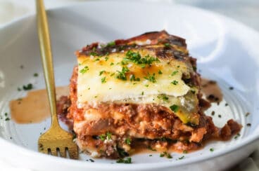 A slice of zucchini lasagna on a white plate.