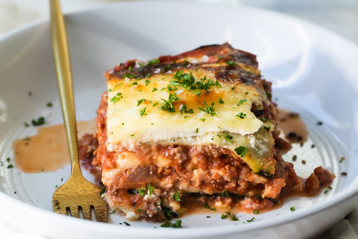 A slice of zucchini lasagna on a white plate.